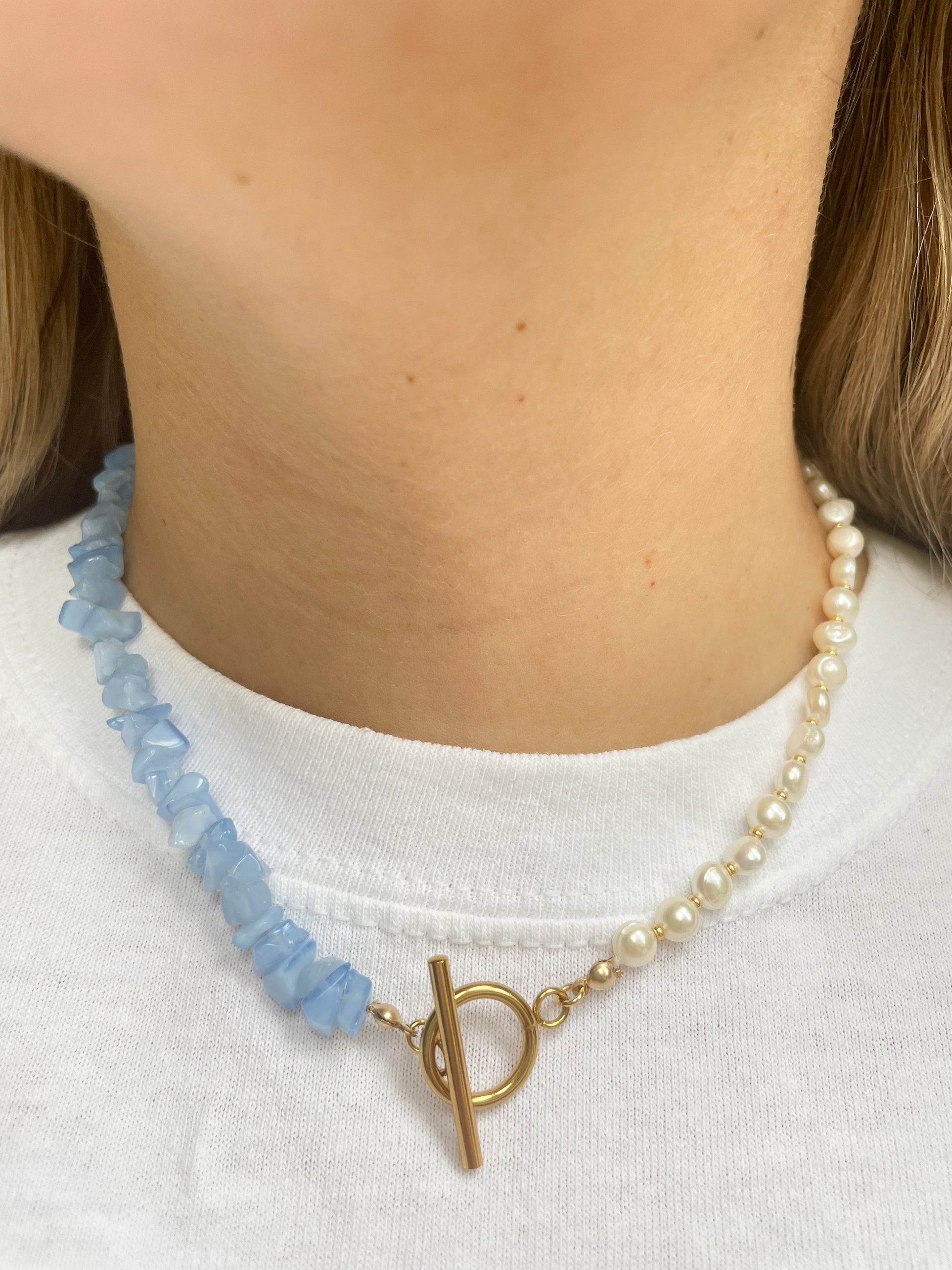 necklace with blue irregular stones and freshwater pearls with a gold clasp at the front