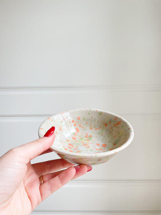 handmade ceramic small bowl with multicolored splatters in orange and green
